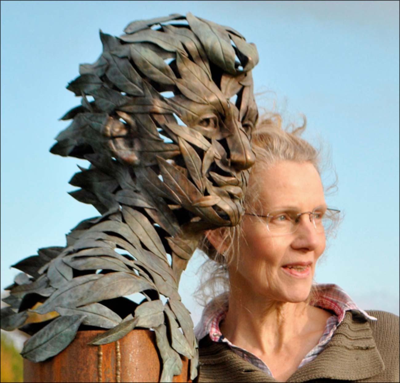 Sioban Coppinger with BLOWN AWAY Sioban Coppinger standing with her sculpture of a young man made of leaves called BLOWN AWAY